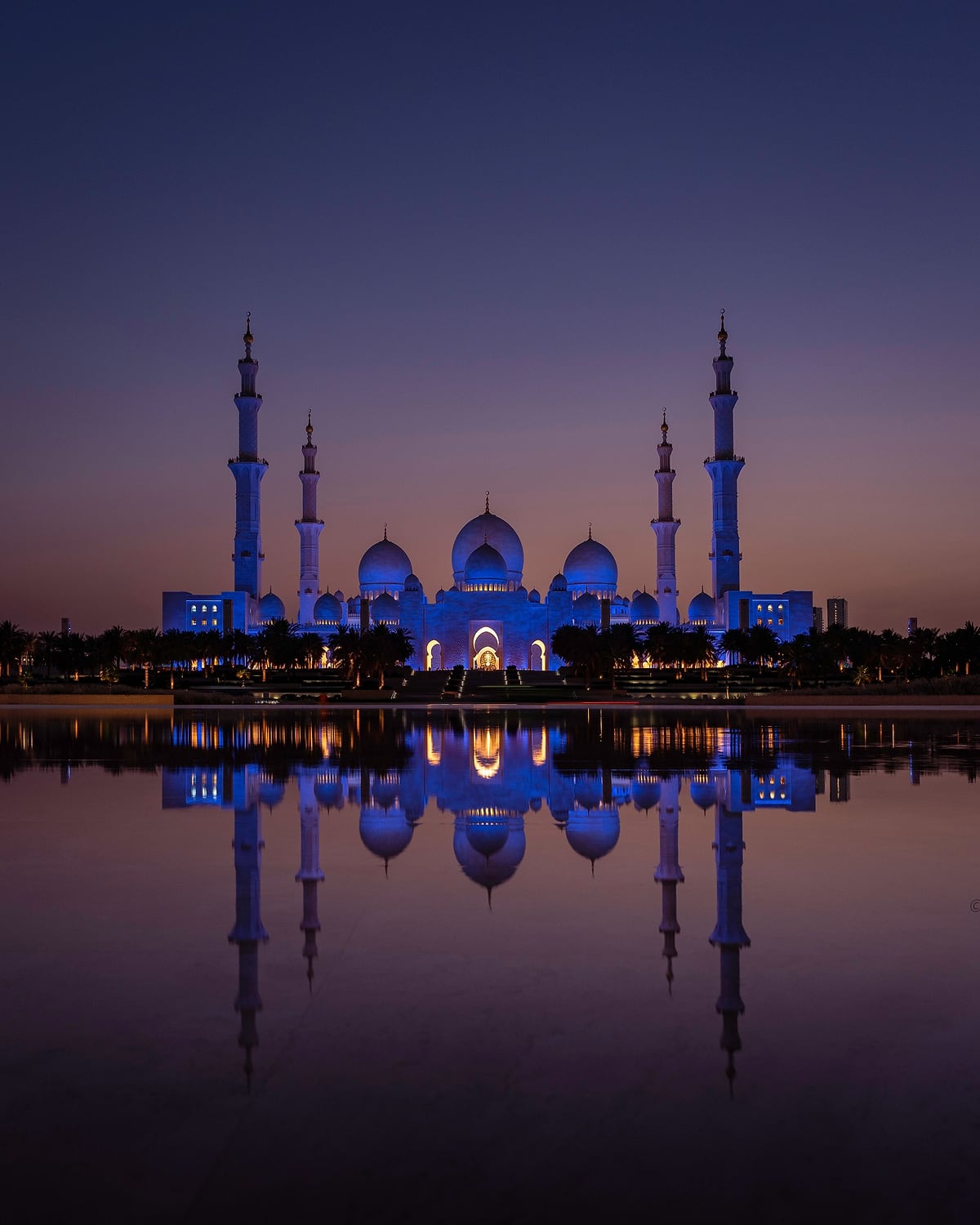 جامع الشيخ زايد الكبير عند الغسق، وينعكس على سطح الماء